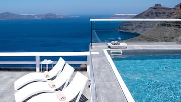 Een buitenzwembad, parasols bij het zwembad en ligstoelen