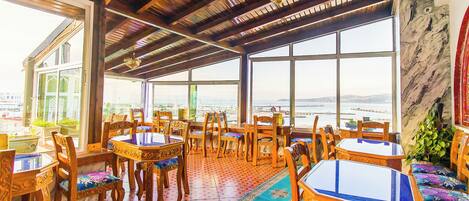 A restaurant with wooden furniture, large windows, and a view of the city.