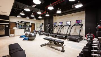 A gym with treadmills, a bench, and various exercise equipment.