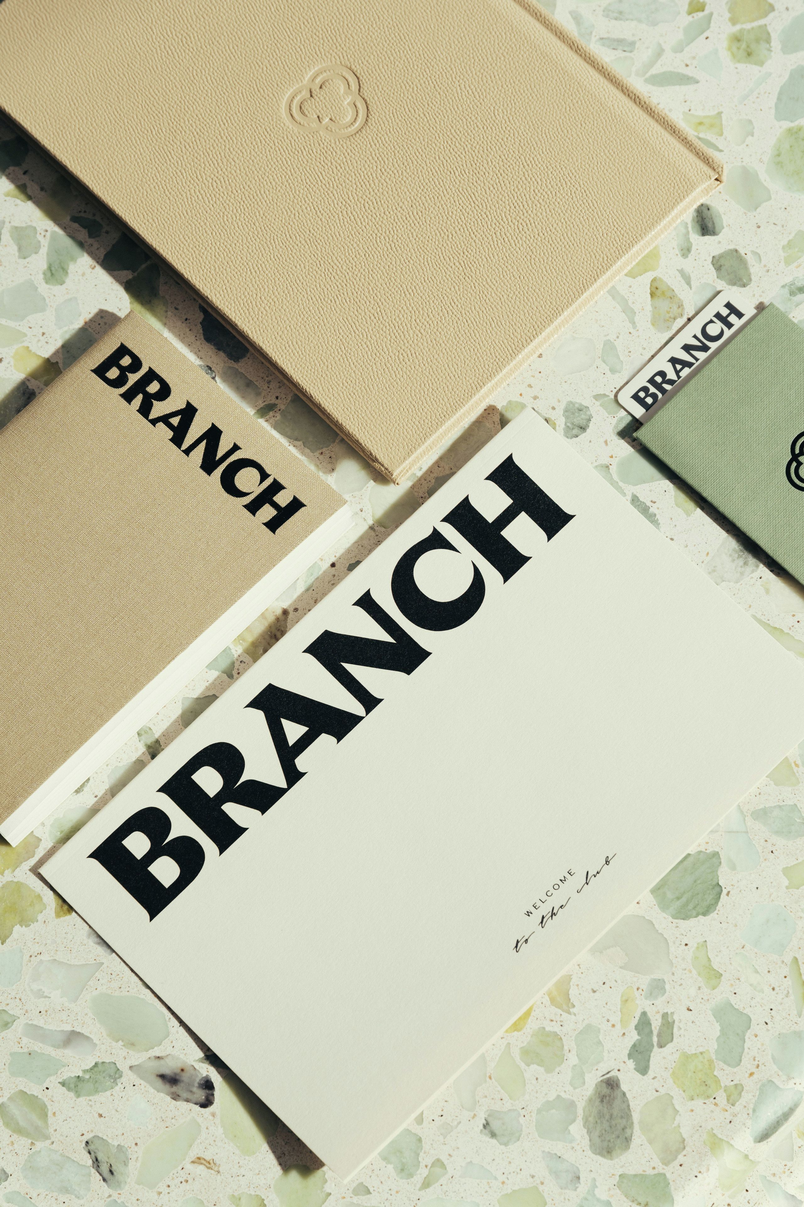 A set of stationery items with the word 'BRANCH' printed on them, placed on a textured surface.