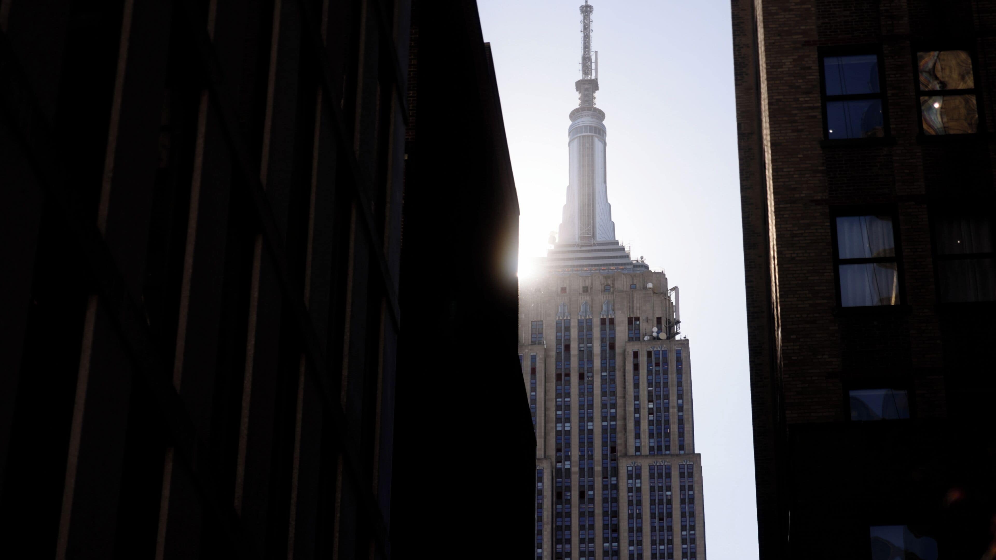 A tall building with a spire, surrounded by other buildings.