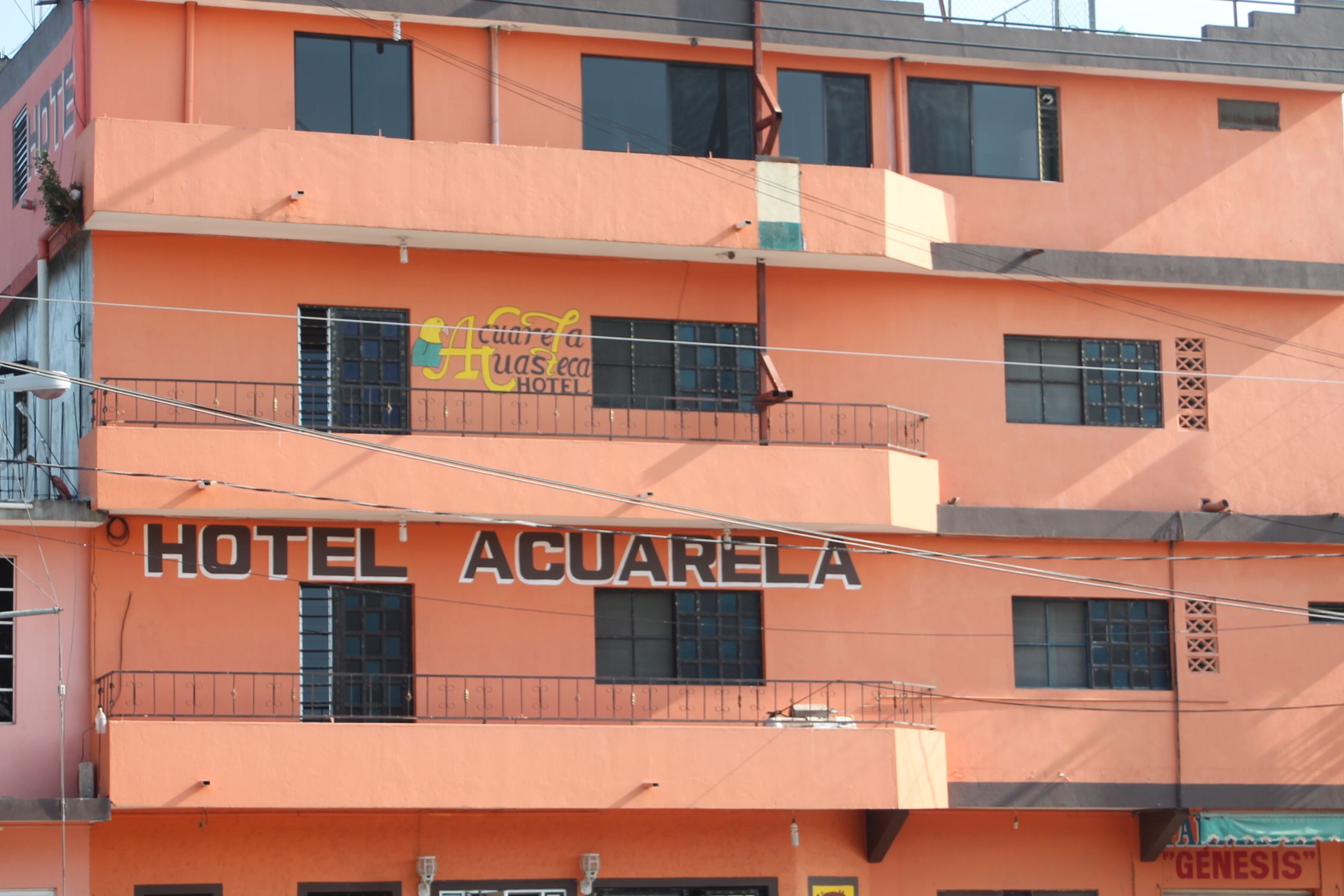 Un edificio de varios pisos con un letrero que dice "HOTEL AQUIARELA".