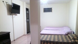 A bedroom with a bed, a television mounted on the wall, and a dresser. - Hotel Acuarela Huasteca (Ciudad Valles)