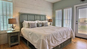 Une chambre à coucher avec un lit, des tables de chevet et une fenêtre.