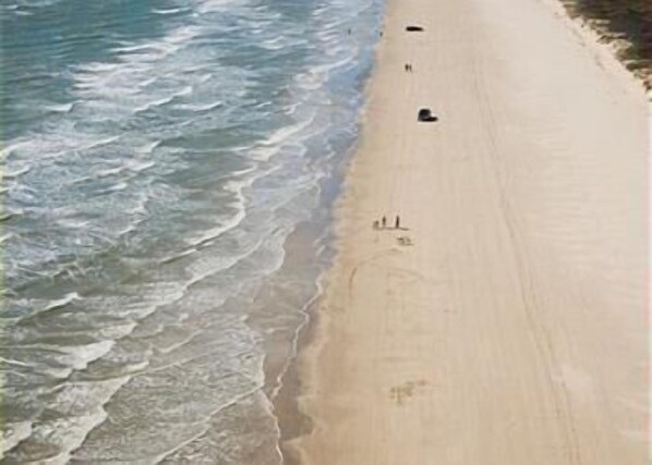 A beach with waves approaching the shore.
