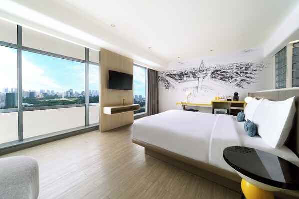 A modern hotel room with a large bed, a desk, a flat-screen TV, and a city view. - YELLO Hotel Harmoni Jakarta (Jakarta)