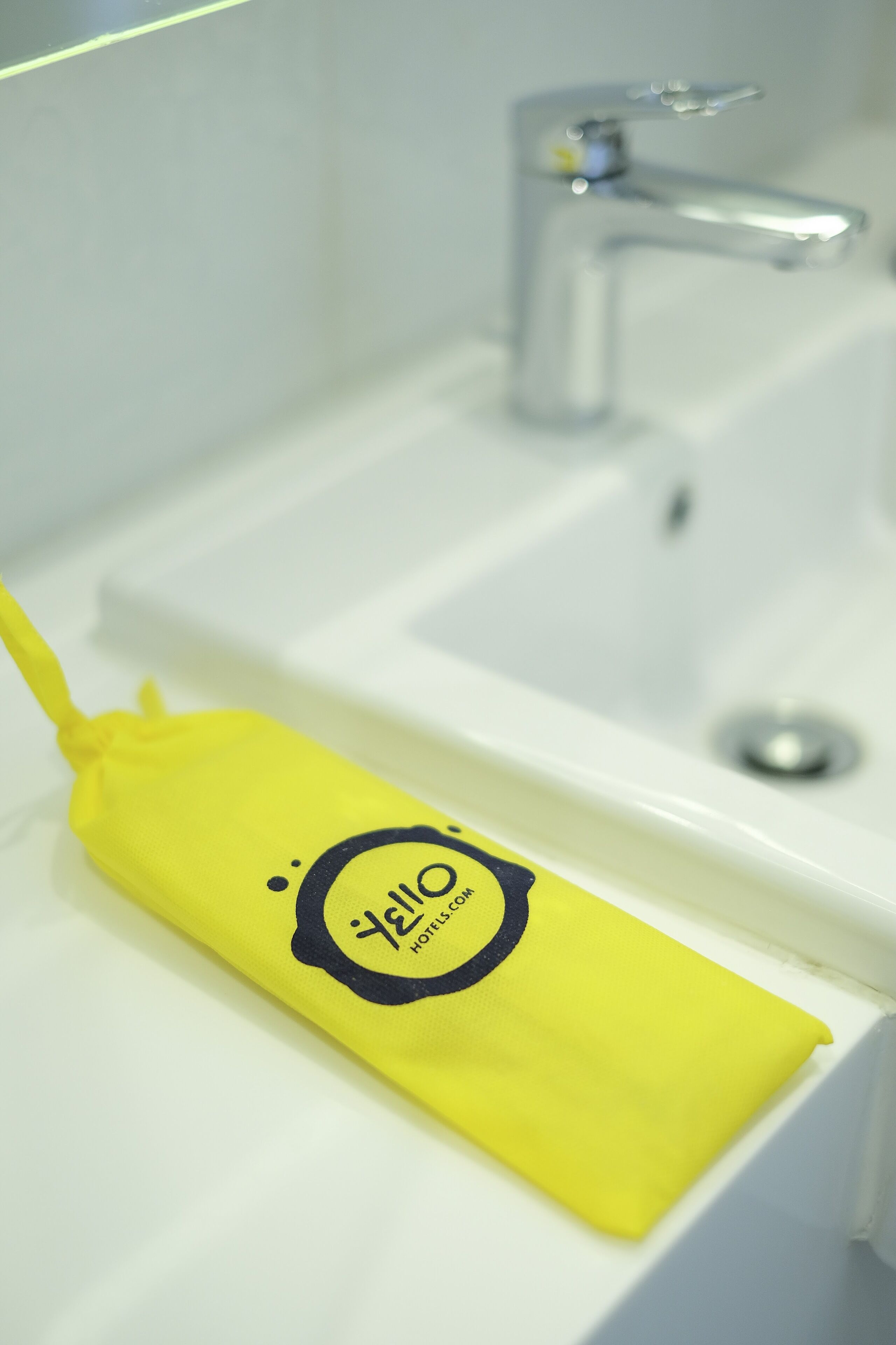 Una tela amarilla con un logotipo sobre un lavabo blanco.