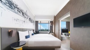 Una habitación de hotel moderna con una cama grande, un televisor de pantalla plana y vistas a la ciudad.