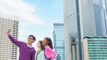 A group of people taking a selfie in front of tall buildings.