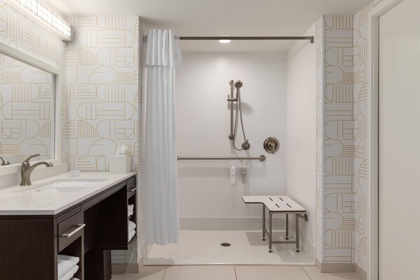 A modern bathroom with a shower, a vanity with a mirror, and a toilet.