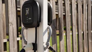 Uma estação de carregamento com um código QR, um cabo e um conector.