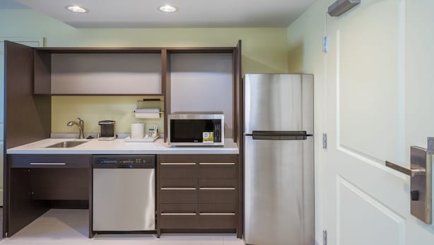 A modern kitchen with built-in appliances, including a dishwasher, microwave, and refrigerator.