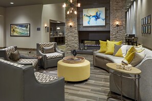 A modern living room with a fireplace, seating, and artwork. - Homewood Suites by Hilton Los Angeles Redondo Beach (Redondo Beach)