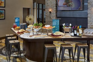 Bar de buffet con diversas opciones de comida, entre ellas ensaladas, salsas y una selección de vinos.