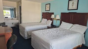 Habitación de hotel con dos camas, un escritorio y una silla.