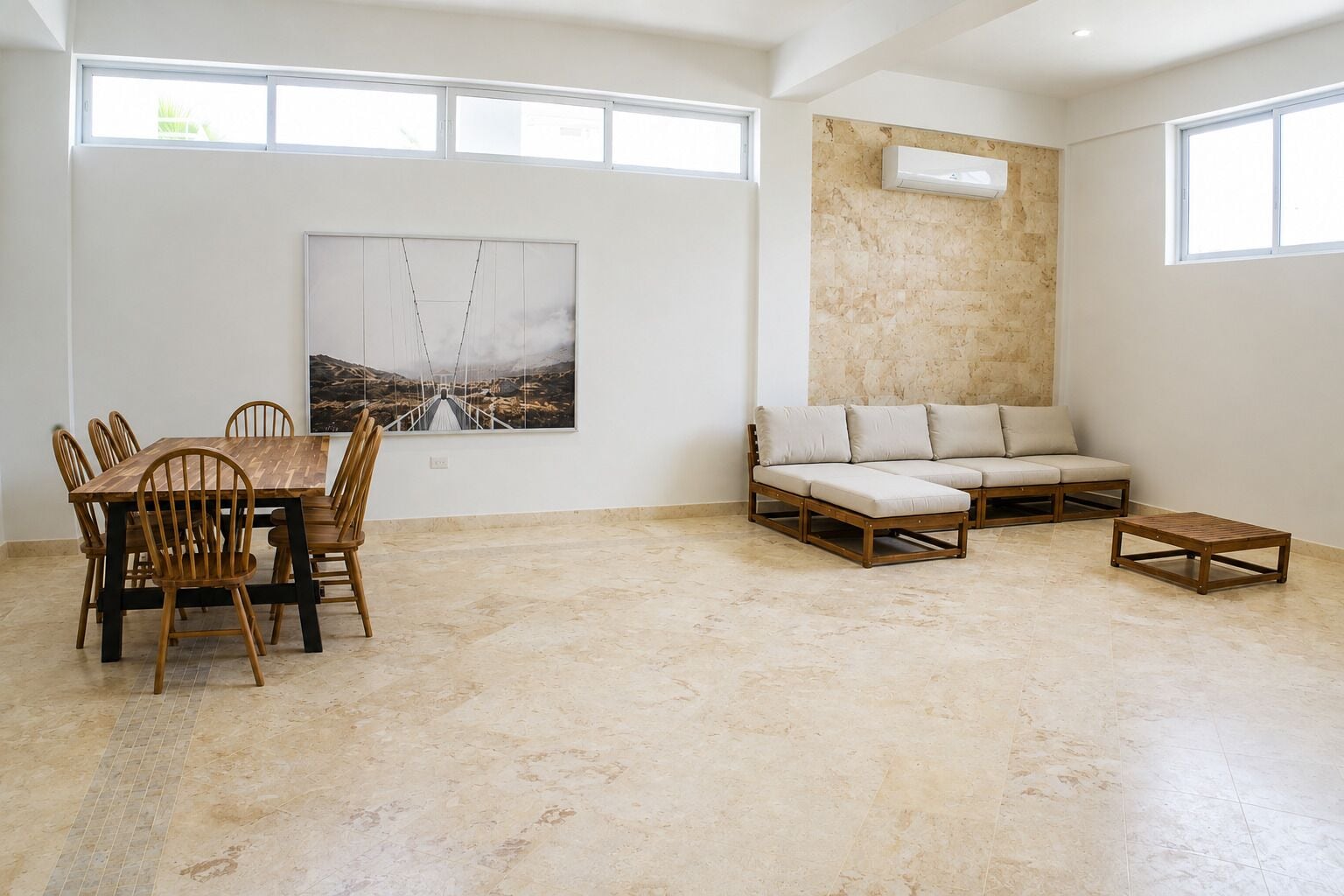 A spacious room with a dining table and chairs, a sofa, and a small coffee table.