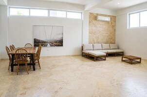 A spacious room with a dining table and chairs, a sofa, and a small coffee table.