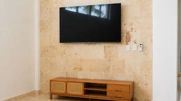 Un televisor de pantalla plana montado en la pared, con un mueble de madera debajo.