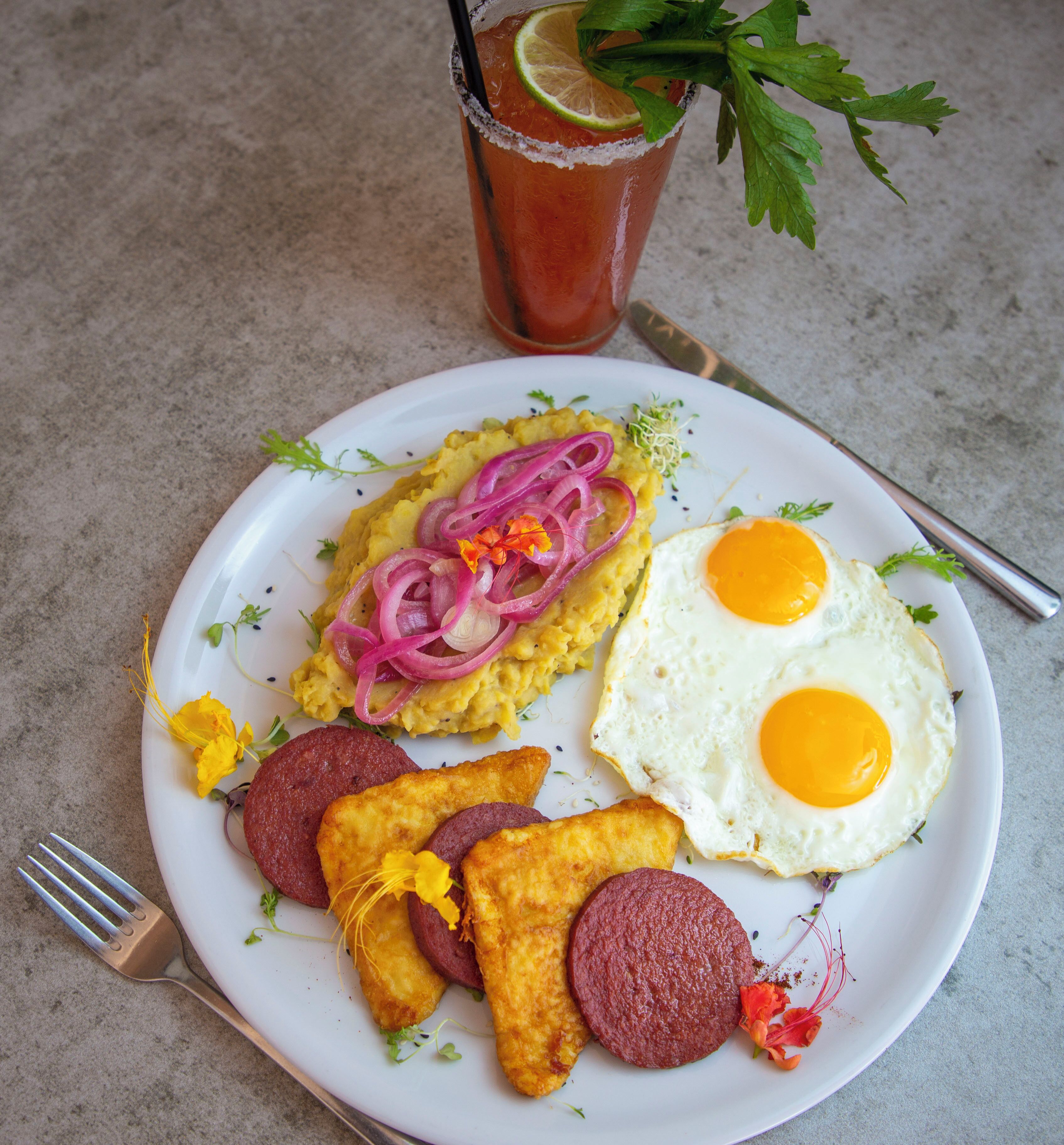 Un plato con huevos revueltos, huevos fritos y salchichas.