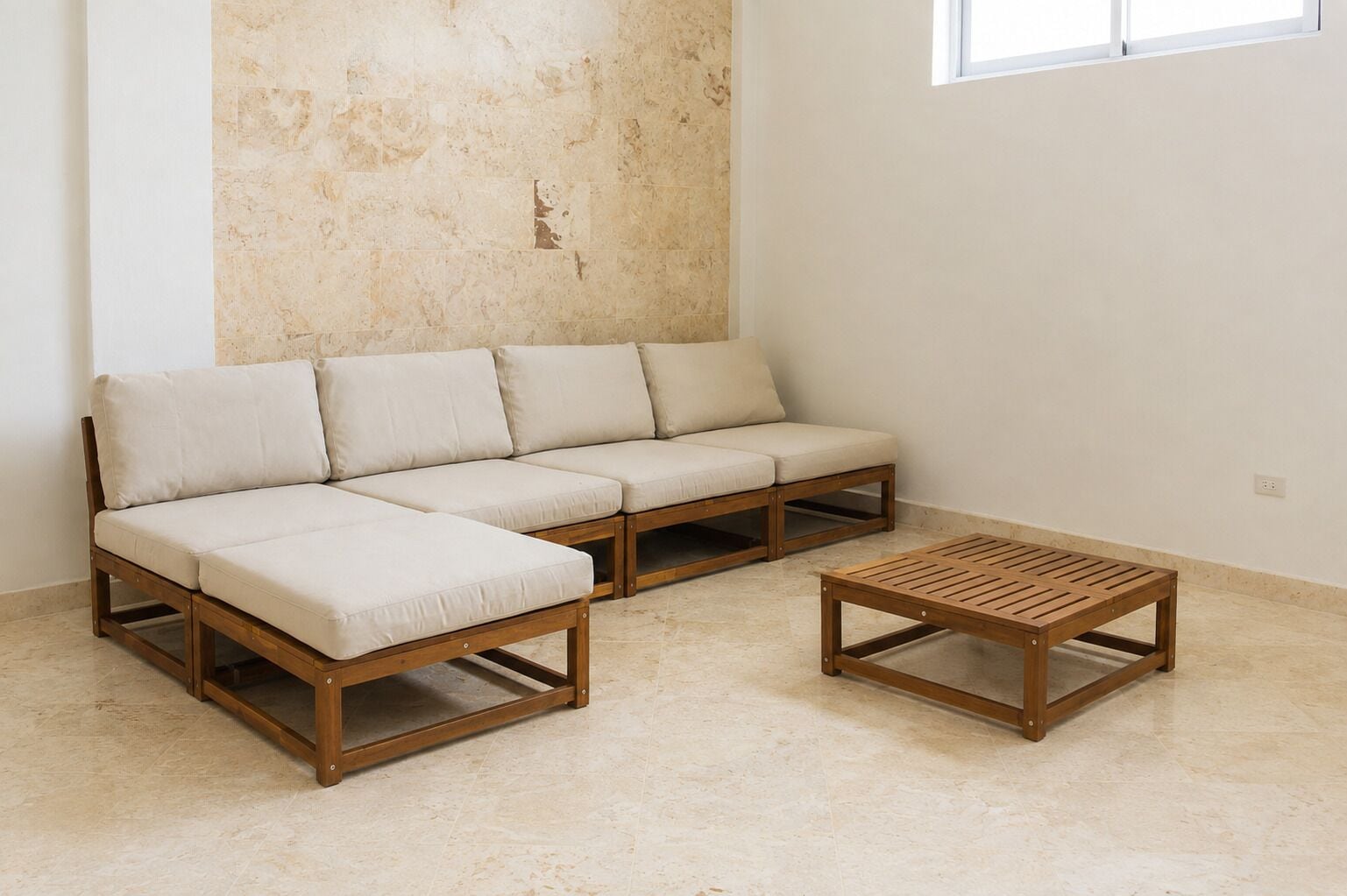 Ein modulares Sofa mit Holzrahmen und hellen Kissen, ein Holztisch und eine schlichte Wand mit einem Fenster.
