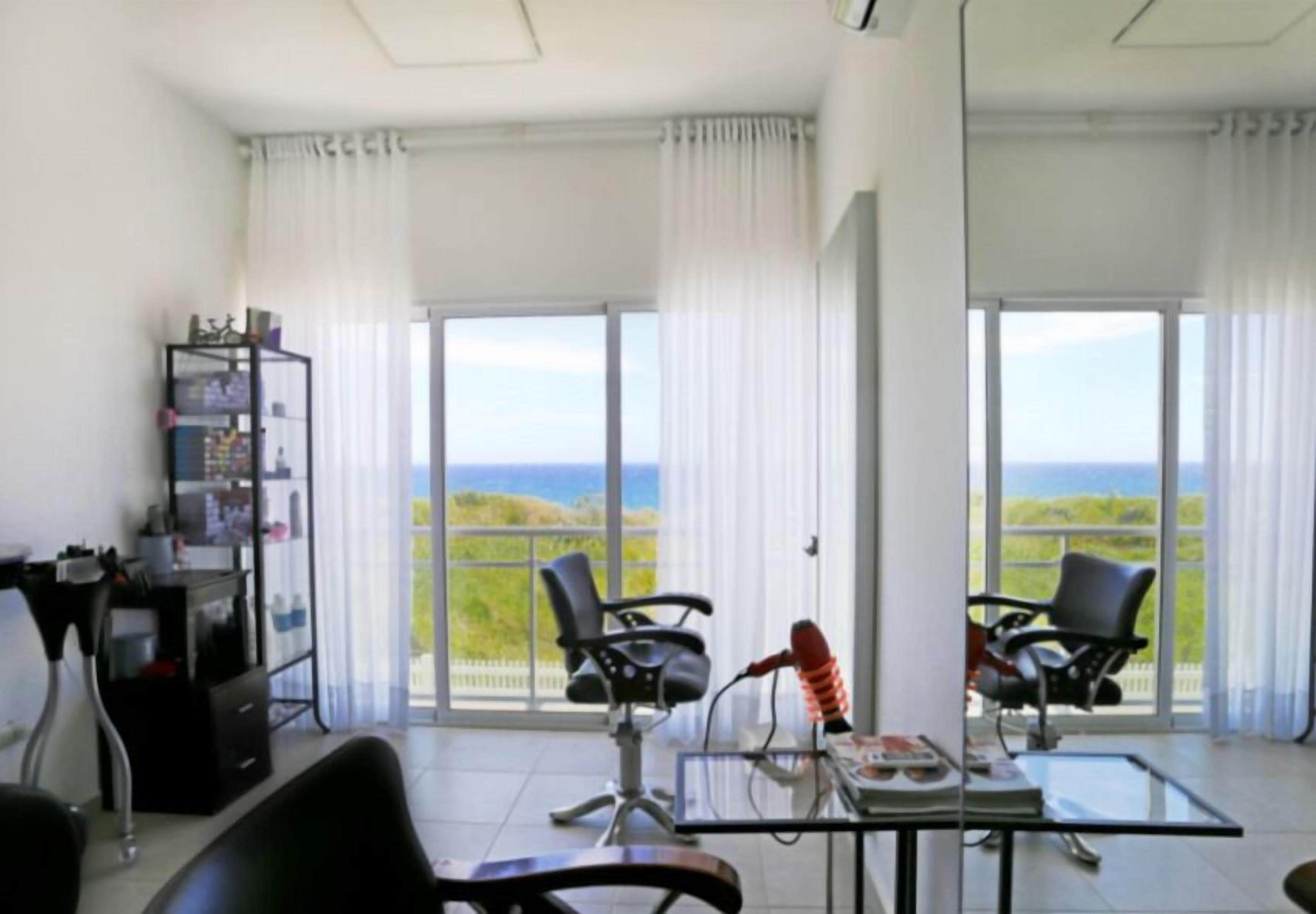 Une chambre avec un balcon, un bureau, deux chaises et une bibliothèque.