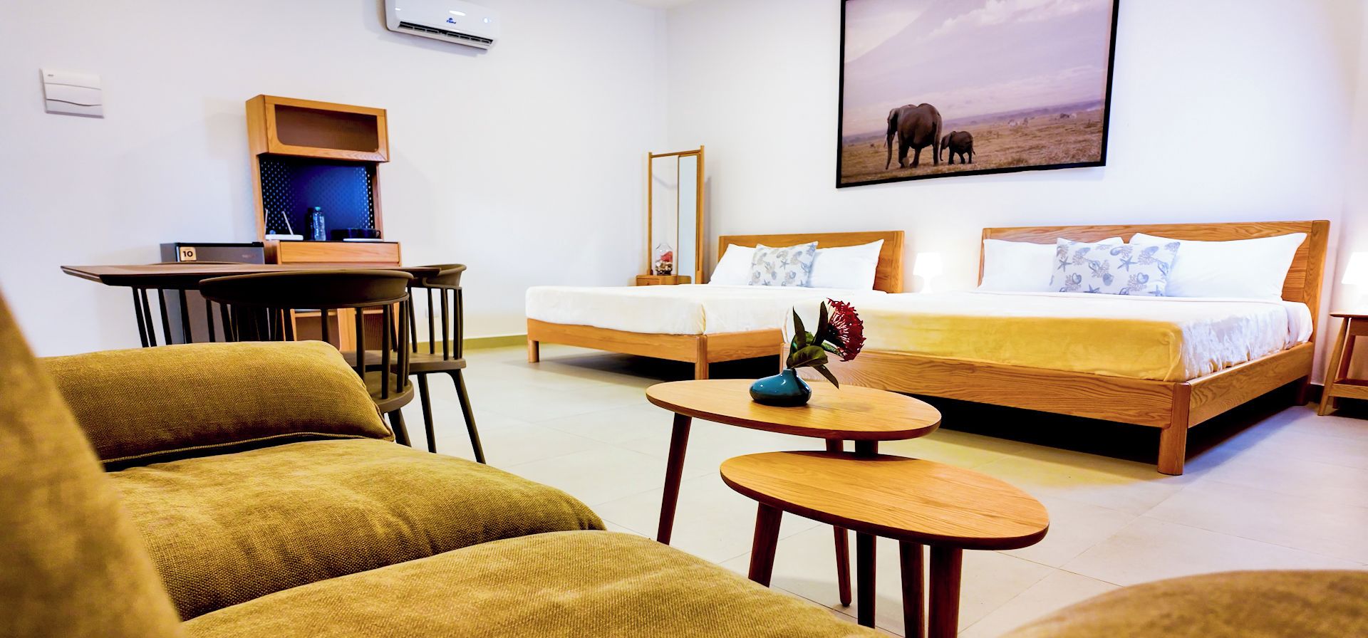 Una habitación de hotel con cama, dos sillas, un escritorio y una mesita.