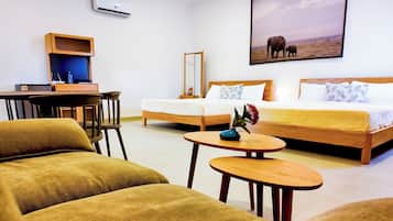 A hotel room with a bed, two chairs, a desk, and a small table.