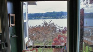 Una habitación con un ventanal grande que ofrece vistas a un lago y árboles.