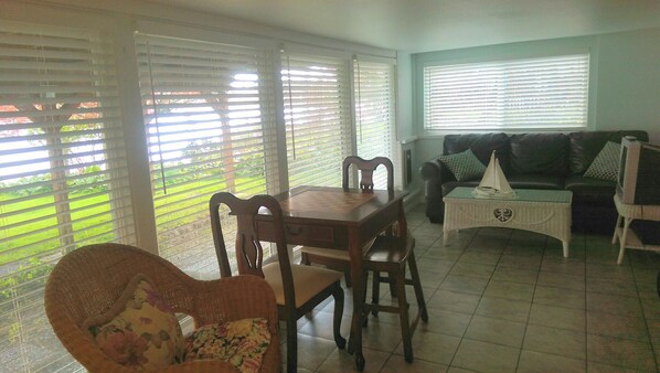 Una sala de estar con una mesa de comedor, sillas, un sofá y una mesa de centro.