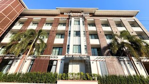 Un hotel de varios pisos con un cartel llamativo que dice 'BAAN PHOR PHAN HOTEL'.