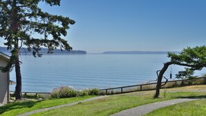 A view of a lake with a wooden deck and a building in the foreground.