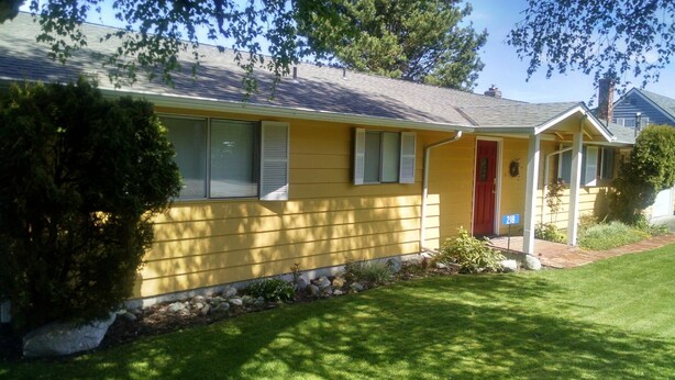A yellow house with a red door, a front porch, and a mailbox. - 6th Street Langley Vacation House (Langley)
