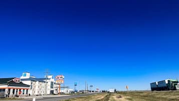 A commercial area with a large A&W restaurant and a truck on the road.