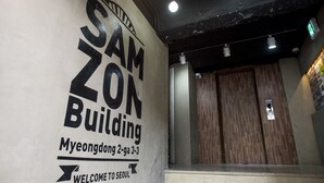 A sign for Samzon Building with a welcome message and directional arrows. - Philstay Myeongdong Metro (Seoul)