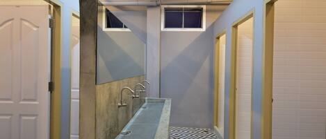 A narrow hallway with a built-in sink and a mirror.