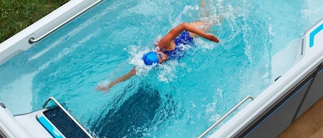 Una piscina al aire libre, sillones reclinables de piscina