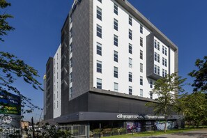 A modern hotel with a prominent CityExpress Plus sign, large windows, and a flat roof. - City Express Plus by Marriott Bogota Aeropuerto (Bogotá)