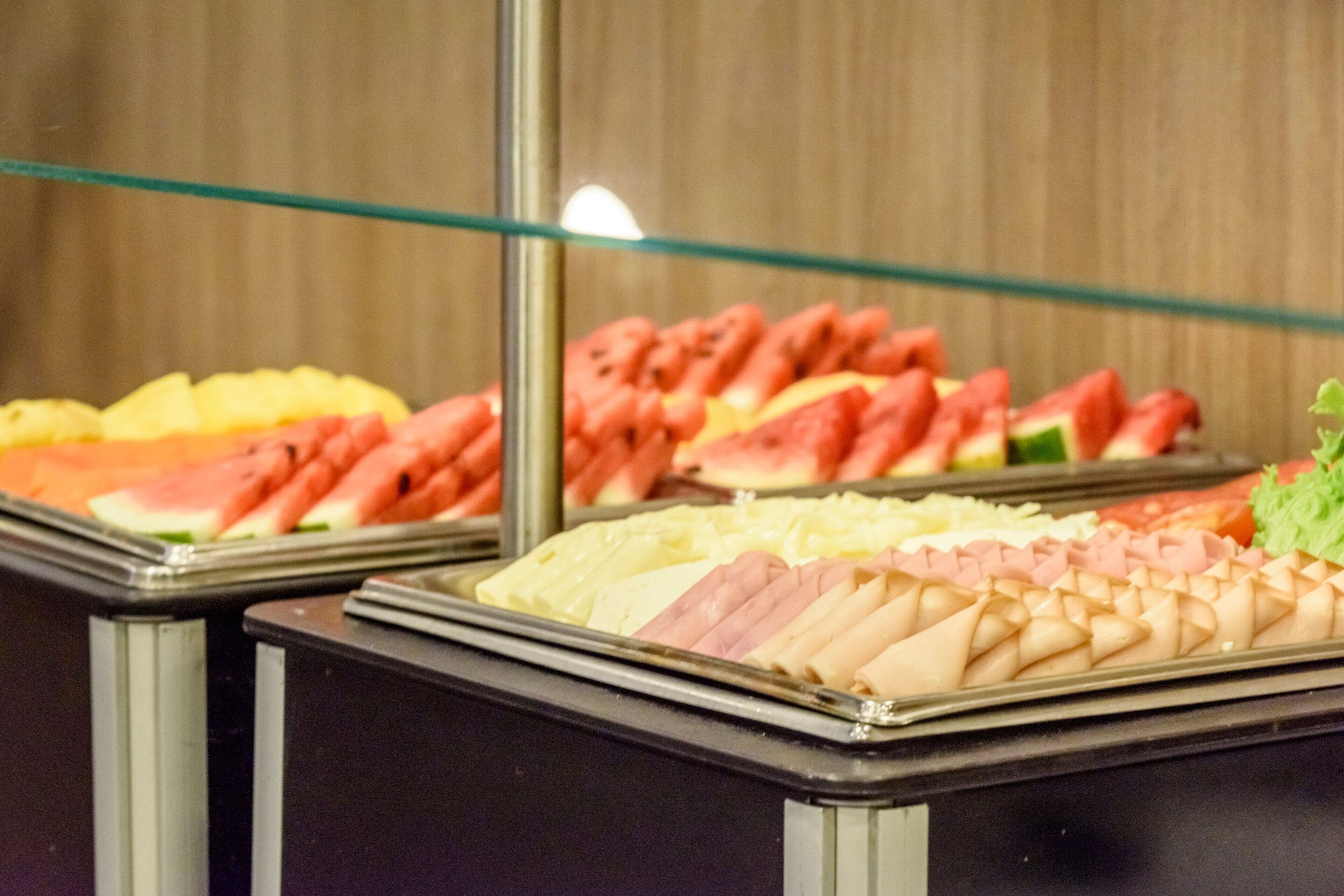 A buffet with various food items including fruits and meats.