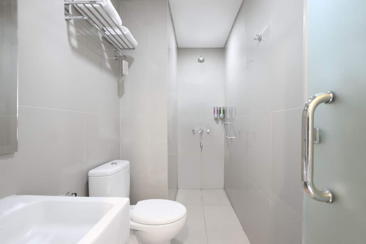Een moderne badkamer met een bad, toilet en douche.