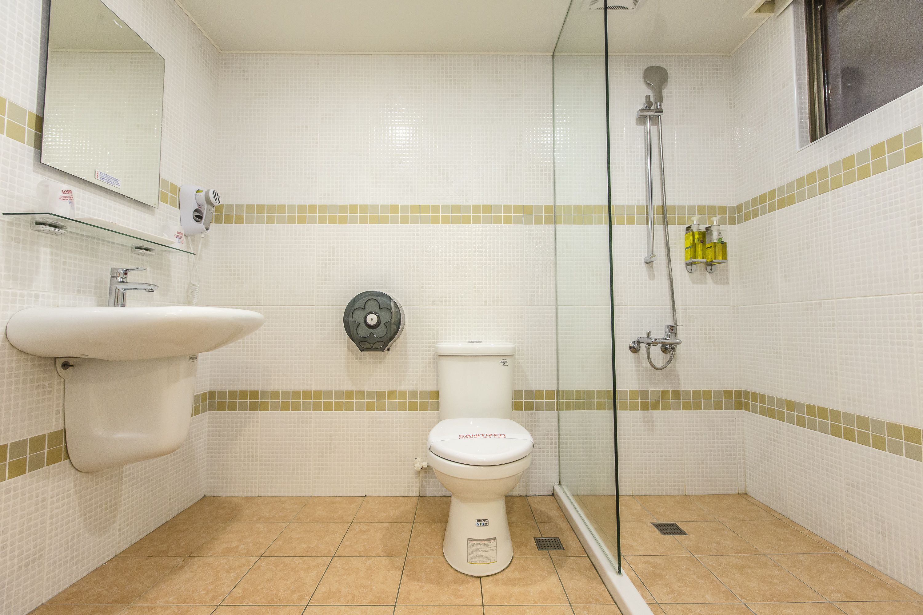 Un baño con inodoro, lavabo y ducha.