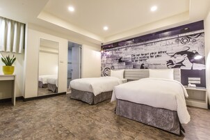 Habitación de hotel con dos camas, un espejo, una planta en maceta y un mural en la pared.