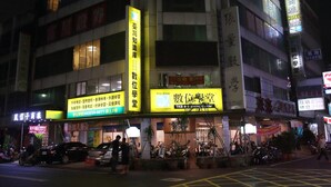 A multi-story hotel with illuminated signage and a parking lot with yellow grid lines. - Fun House - Douliu Branch (Douliou)