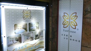 A hotel interior with a large illuminated display featuring the Funhouse logo and interior images. - Fun House - Douliu Branch (Douliou)
