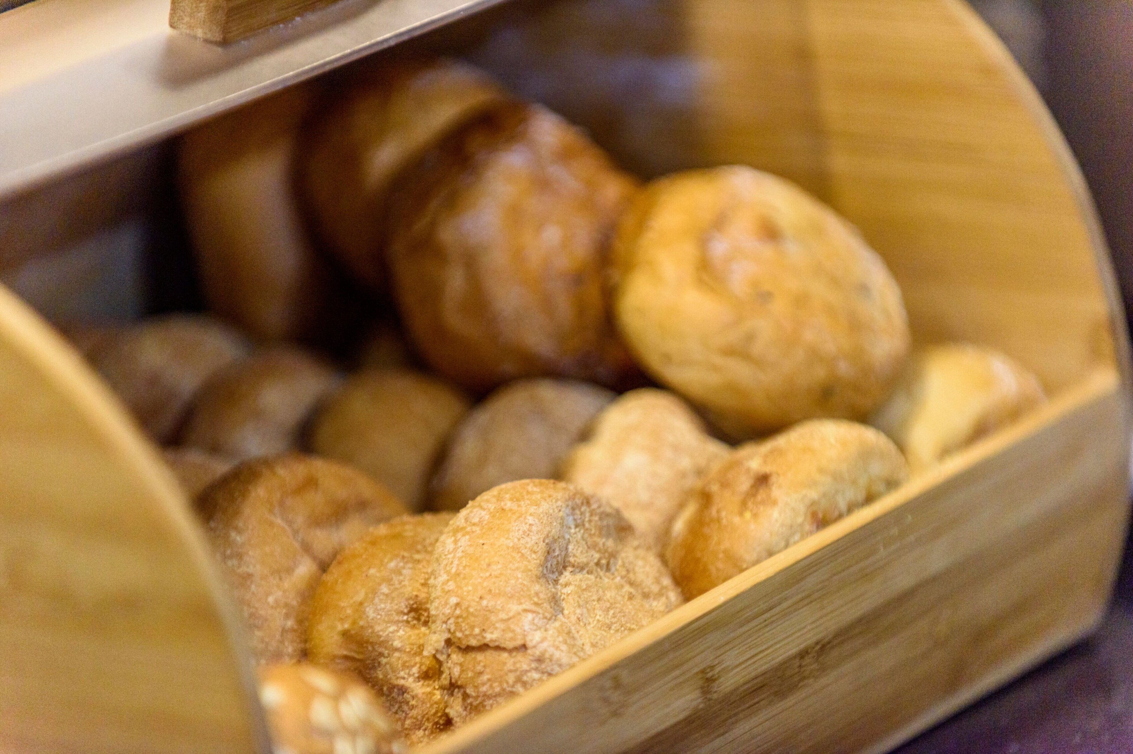 Een houten mand gevuld met verschillende soorten brood.
