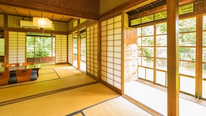 Una habitación japonesa tradicional con suelo de tatami, puertas correderas y detalles de madera.