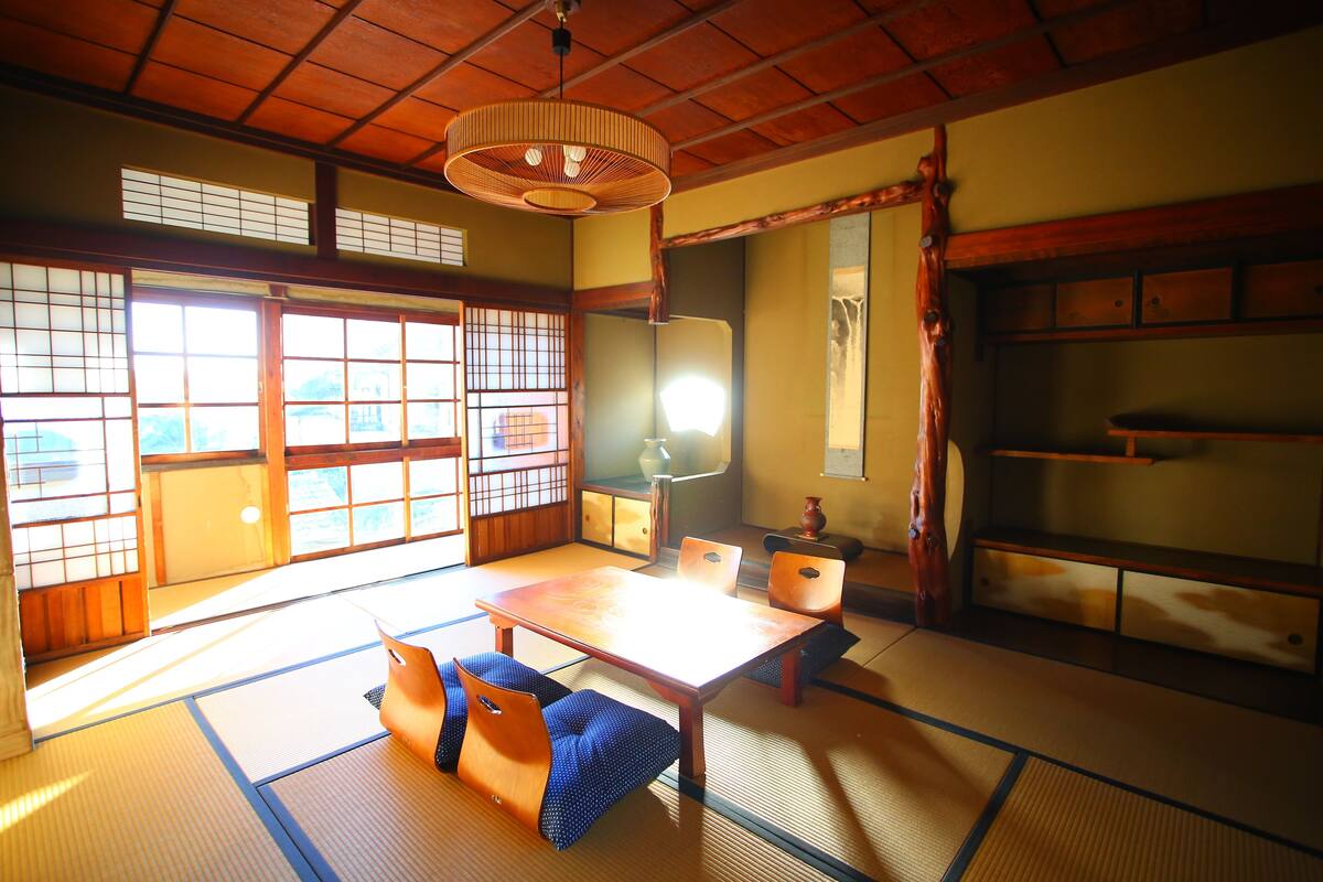 A traditional Japanese room with tatami flooring, a low wooden table, and sliding doors.