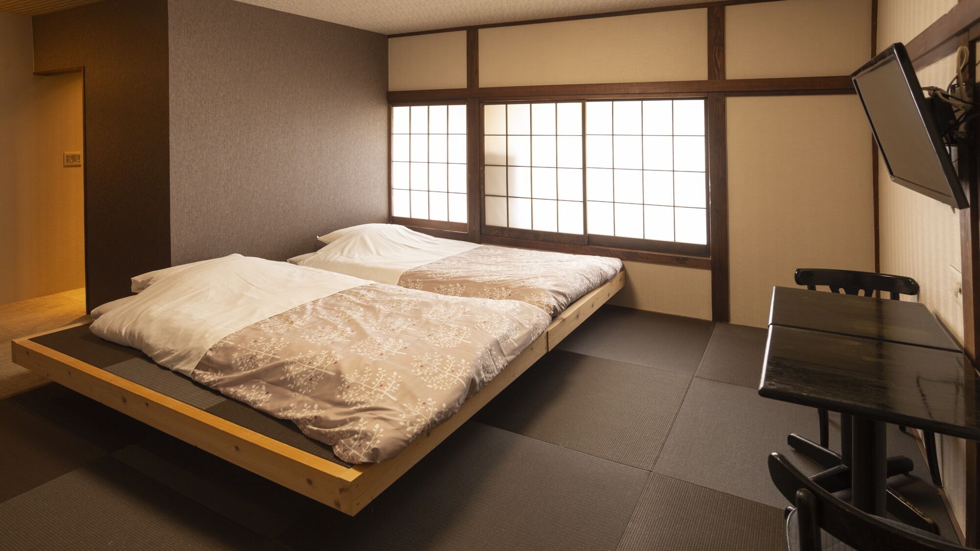 A room with a bed, a desk, and a window with a view.