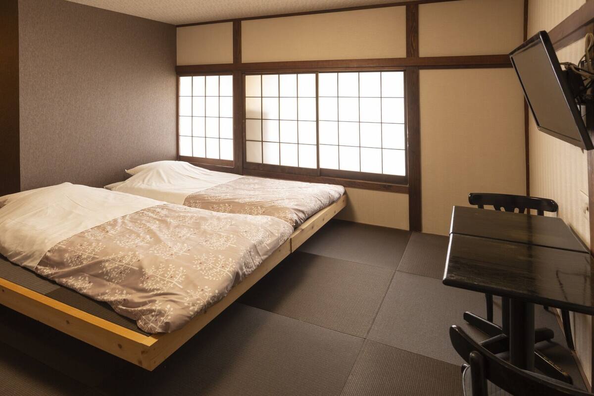 A room with a bed, a desk, and a window with a view.