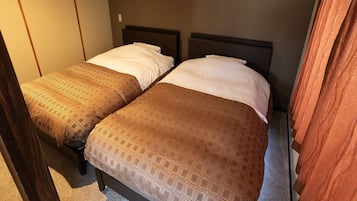 A room with two beds, each with a patterned bedspread and white pillows.