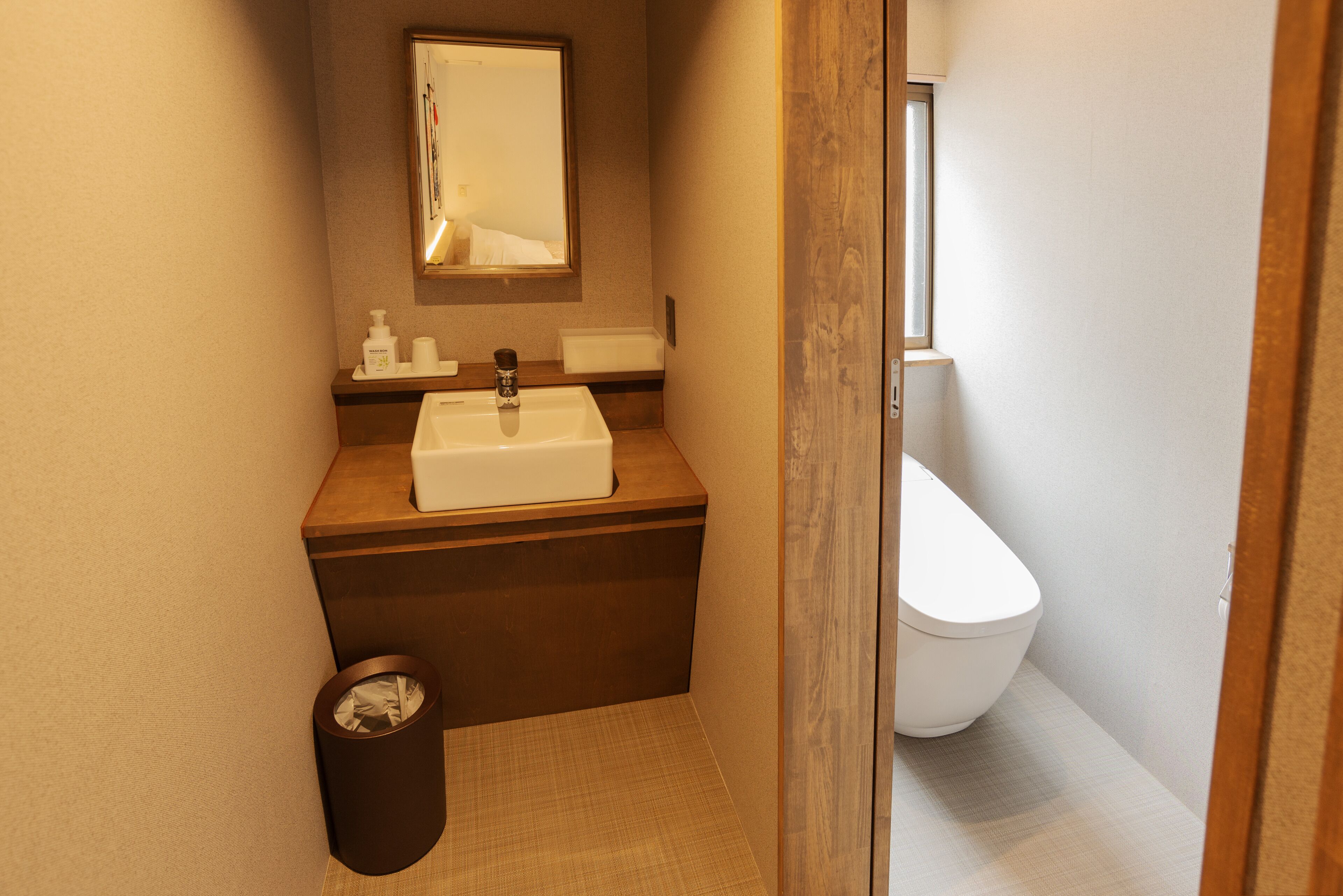 Un baño pequeño con lavamanos, espejo e inodoro.